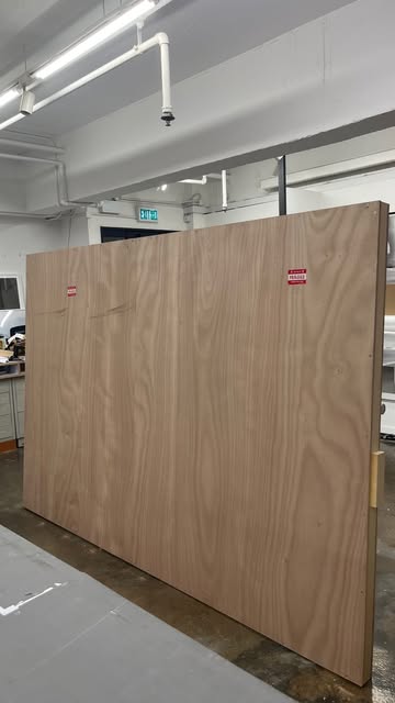 Large plywood panels standing upright in a workshop.